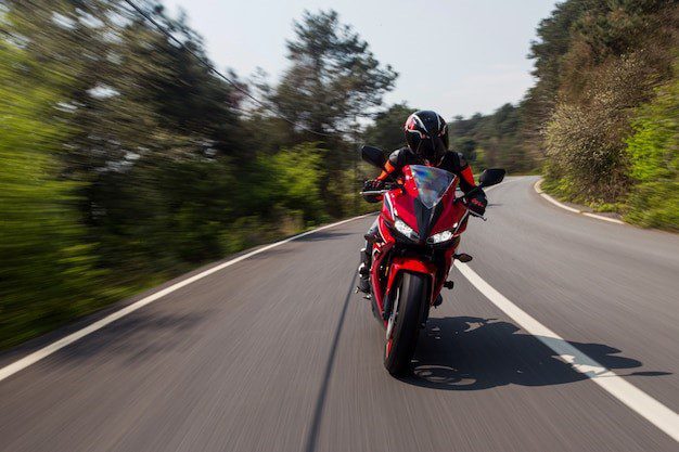 Motorcyclists leaning while taking a curved road