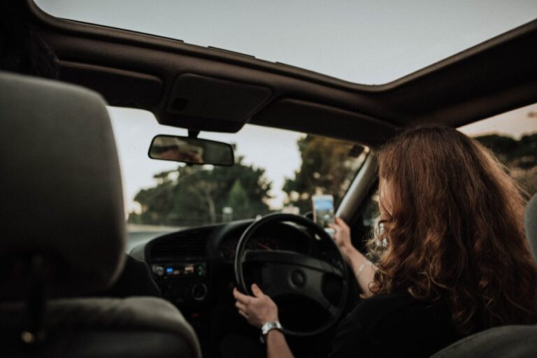 Women distracted with a phone while driving car